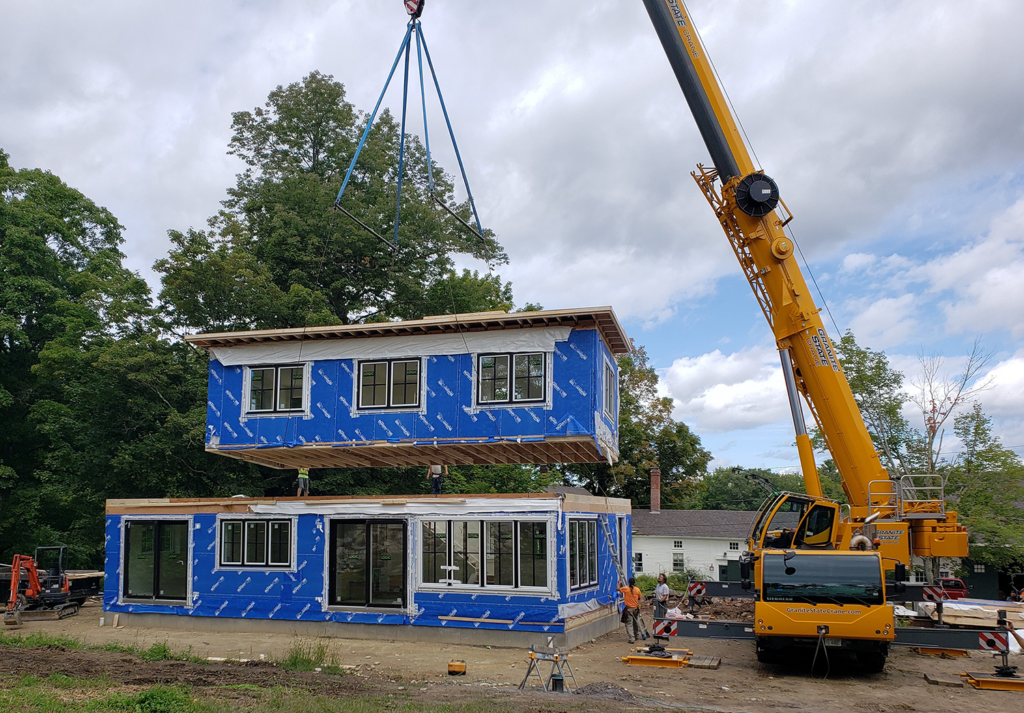 Modular Building FAQs modular units being set on foundation with crane